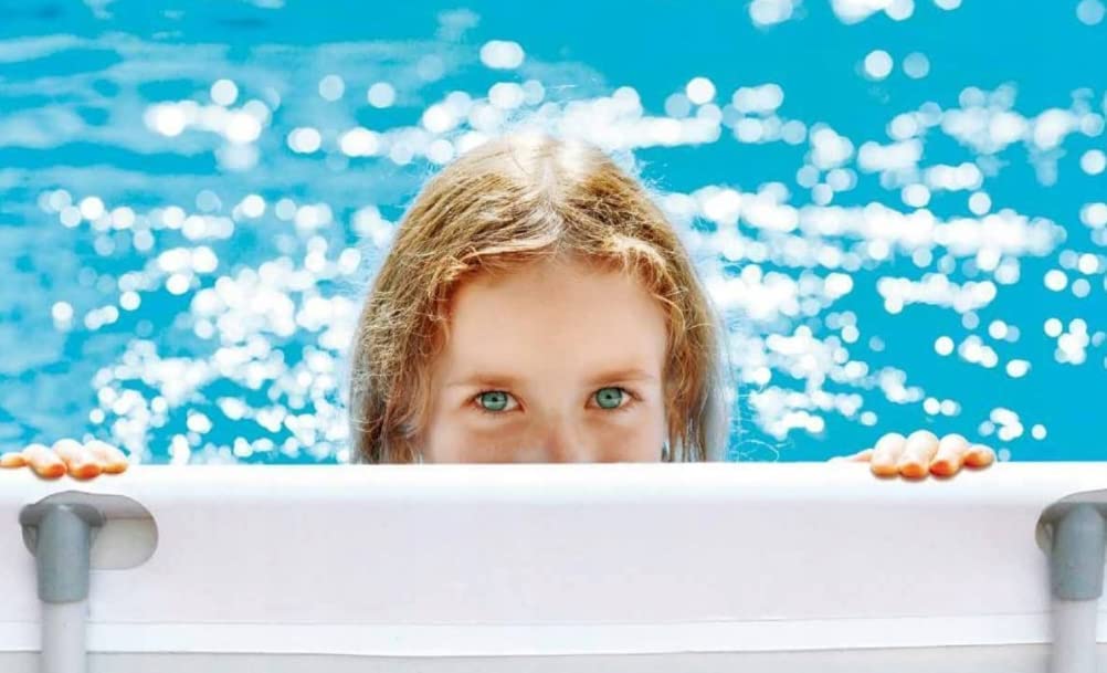 Child peeking over a pool safety cover with blue water in the background