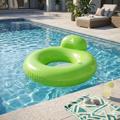 Green inflatable ring with a brand logo floating in a pool, surrounded by lounge chairs and plants.