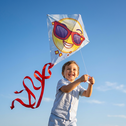 Child flying the emoji plastic kite in a clear blue sky